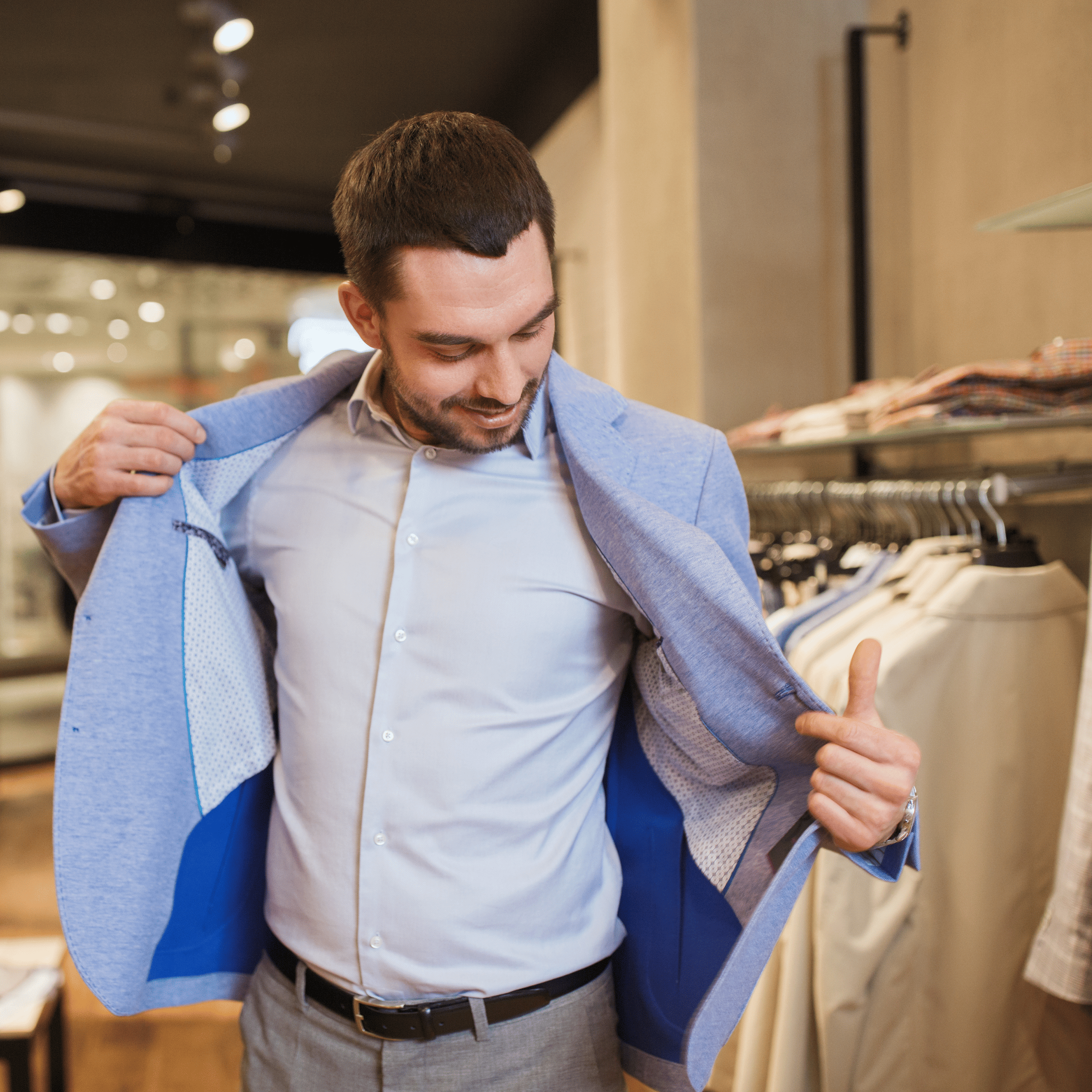Homem experimentando blazer azul em loja de roupas masculinas.
